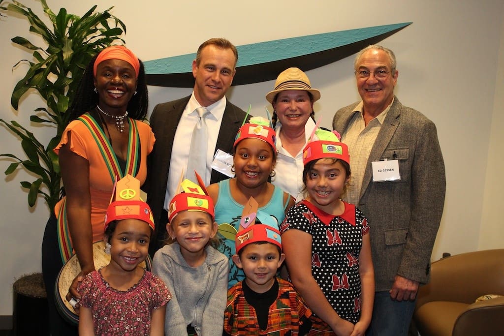 two women, two men, and a group of children wearing handmade felt hats